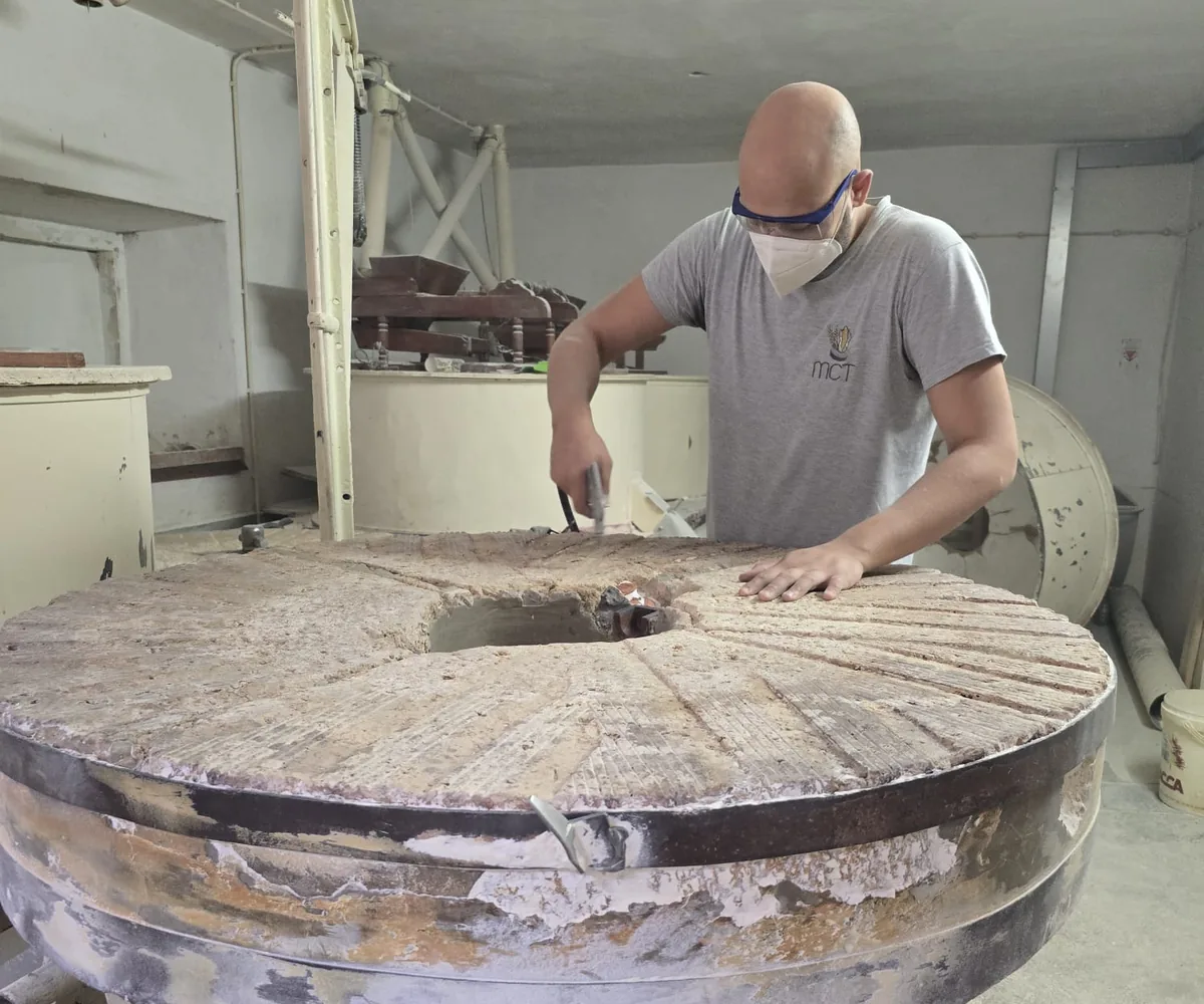 Colaborador da MCT a trabalhar a superfície de uma mó